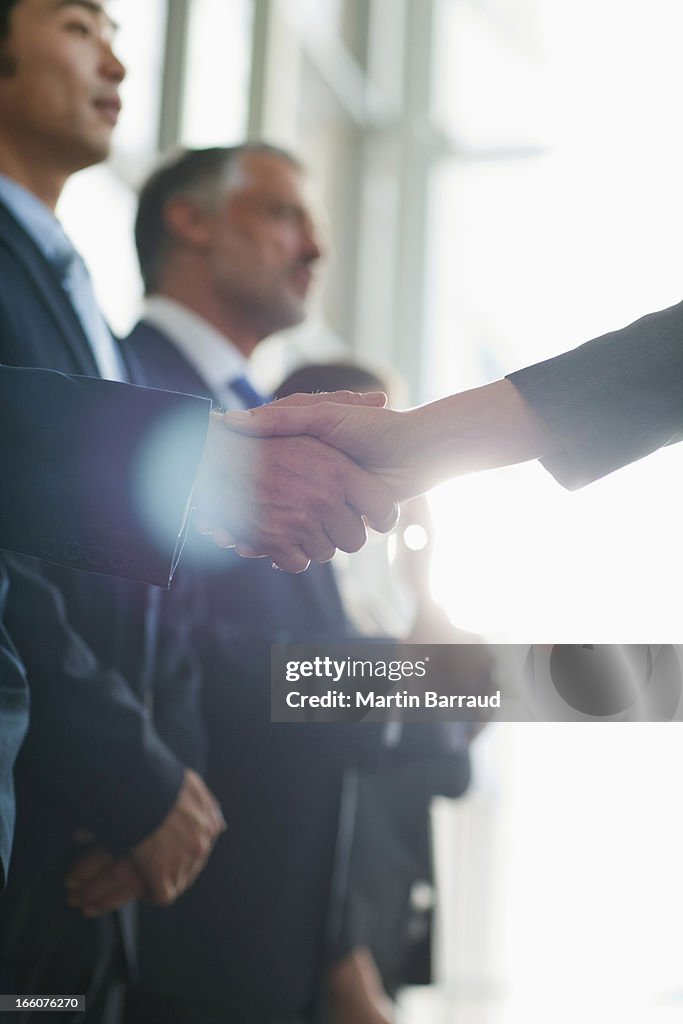 Close up of business people shaking hands in a row