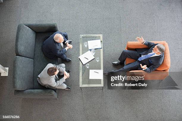 businessmen meeting in lobby - three people on couch stock pictures, royalty-free photos & images