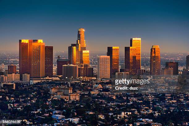 los angeles skyline at sunset thru smog and atmosperic distortion - downtown los angeles aerial stock pictures, royalty-free photos & images