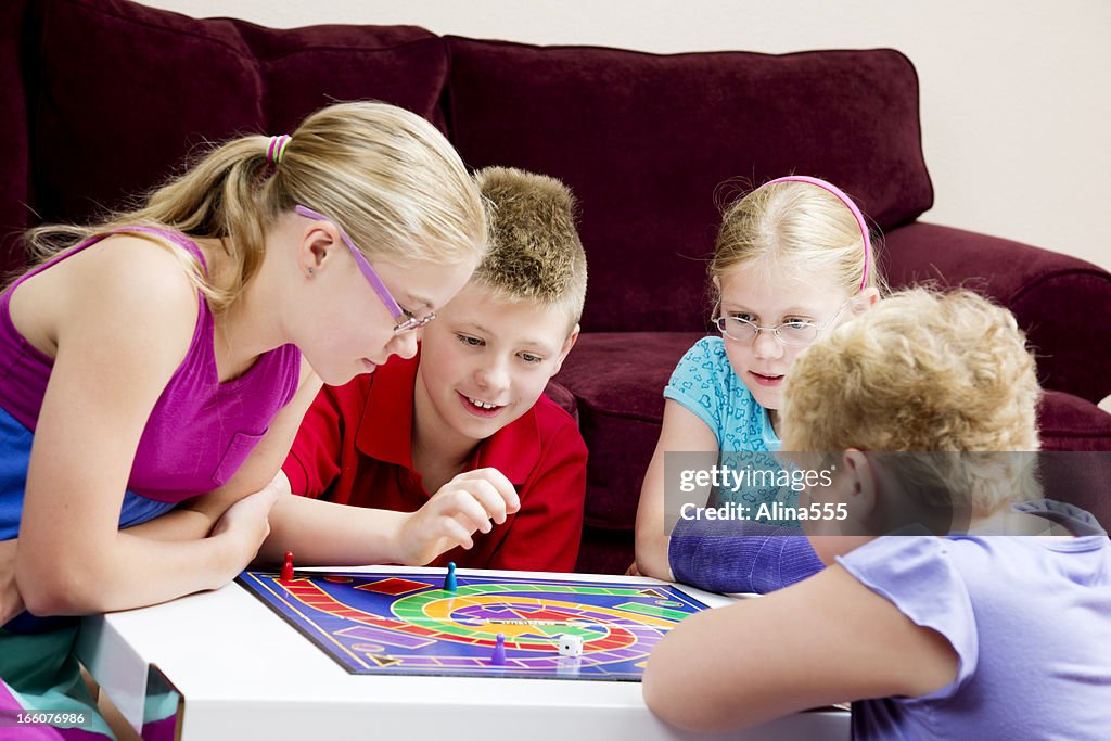 Gruppe der Kinder spielen Brettspiel in einem Wohnzimmer