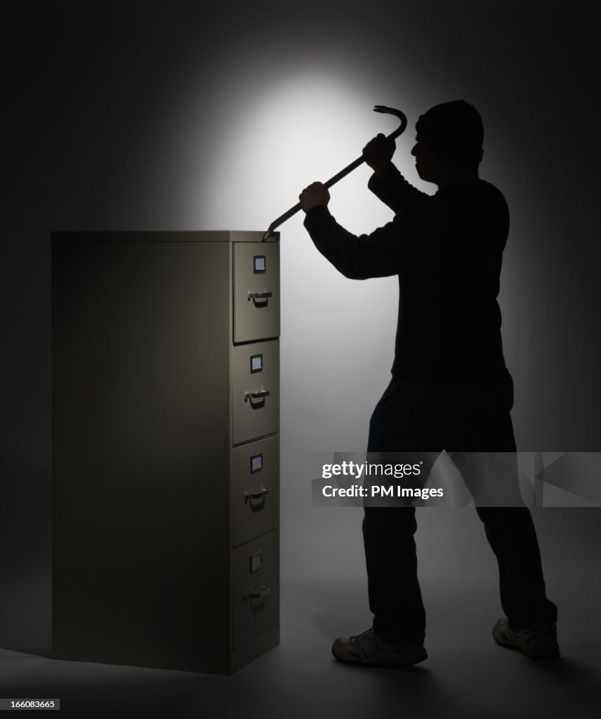 Thief breaking into file cabinet