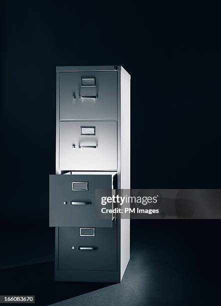 light from open file cabinet drawer - filing cabinet photos et images de collection