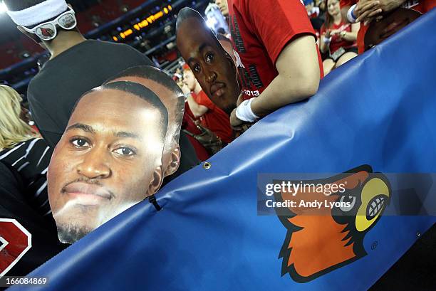 Fans hold signs with the likemess of injured guard Kevin Ware of the Louisville Cardinals against the Michigan Wolverines during the 2013 NCAA Men's...