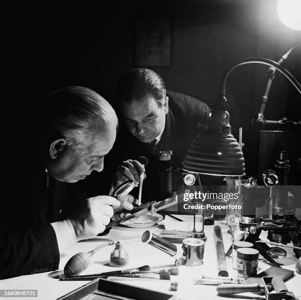 Superintendent Fred Cherrill and his assistant Chief Inspector Burch of the Metropolitan Police Fingerprint Bureau examine fingerprint records at the...