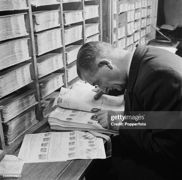 Metropolitan Police detective examines fingerprint records at the Met's fingerprint library inside the New Scotland Yard building on Victoria...