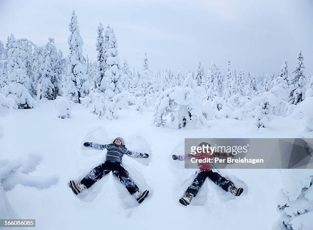 two snow angels in a snowy forest - winter stock pictures, royalty-free photos & images