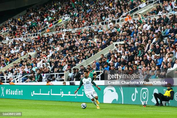 Salem Aldawsari of Saudi Arabia runs down the wing at St James' Park with a Saudi advert on the boards behind during the International Football...