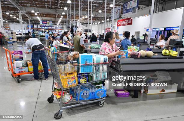 Shoppers place their items on the checkout counter at a wholesale distributor in Alhambra, California on September 12, 2023. Credit card debt from US...