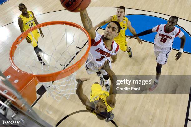 Peyton Siva of the Louisville Cardinals attempts a dunk in the first half against Glenn Robinson III of the Michigan Wolverines during the 2013 NCAA...