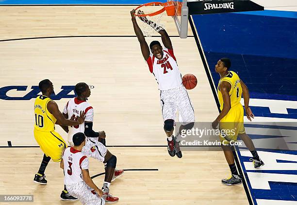 Montrezl Harrell of the Louisville Cardinals dunks an alley-op pass in the first half against Glenn Robinson III of the Michigan Wolverines vduring...