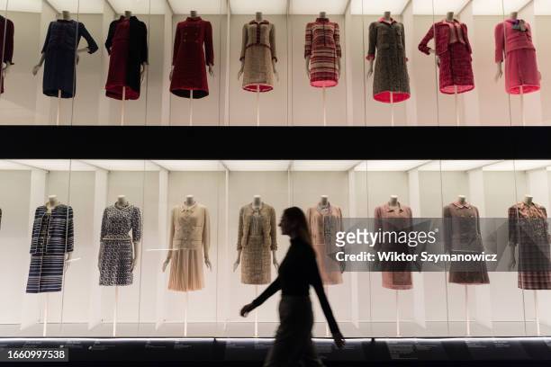 Staff member walks past a multi-level colourful arrangement of classic Chanel tweed suits during a photocall for the upcoming exhibition Gabrielle...