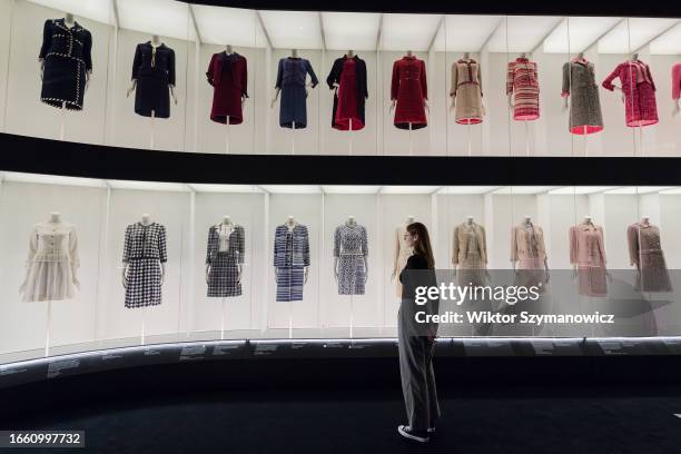 Staff member looks at a multi-level colourful arrangement of classic Chanel tweed suits during a photocall for the upcoming exhibition Gabrielle...