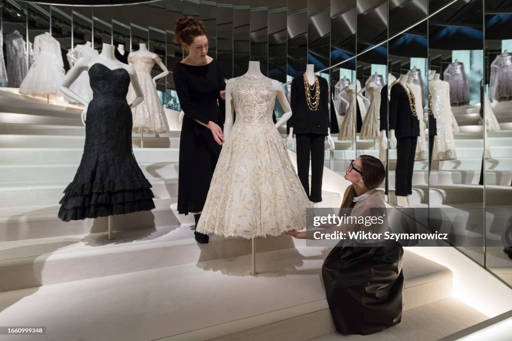 Museum curators pose with Chanel evening gowns displayed on a Fotografía  de noticias - Getty Images