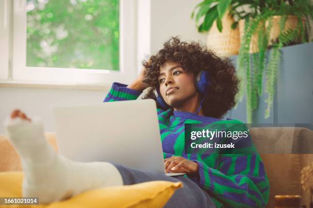 sad young woman with broken leg resting at home - jade stock pictures, royalty-free photos & images