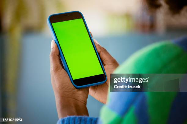 woman using mobile phone at home - iphone hand green screen stock pictures, royalty-free photos & images