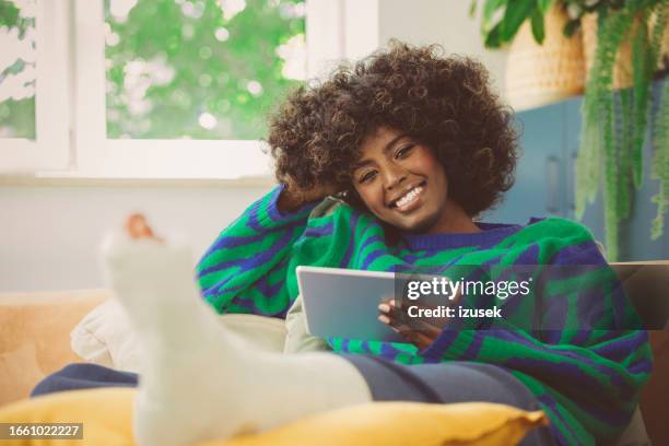 young woman with broken leg using ipad at home - jade stock pictures, royalty-free photos & images