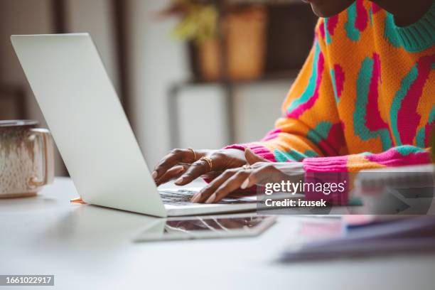 mujer escribiendo en el teclado del ordenador portátil - usar el ordenador fotografías e imágenes de stock