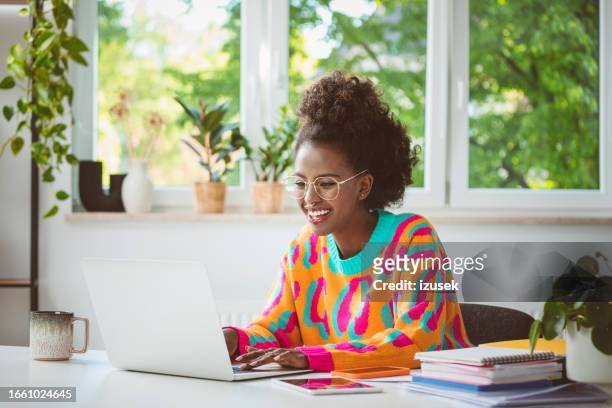 young woman working at home, using laptop - generation z laptop stock pictures, royalty-free photos & images
