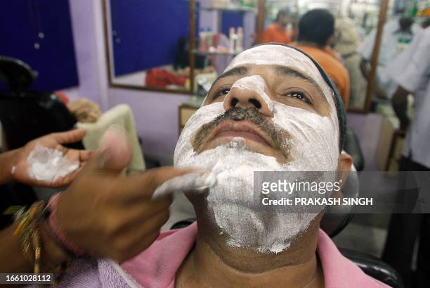 Indian man Iqbal gets a layer of face cream as he receives a facial massage at a men's beauty parlour in New Delhi, 05 September 2007. In a new...