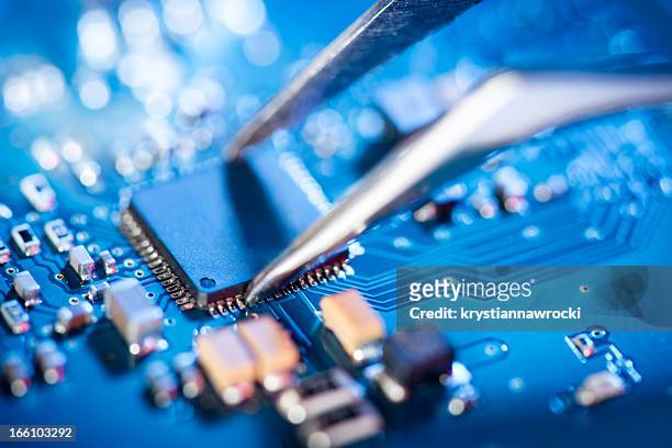 technicien électronique en pince chirurgicale et assemblin un circuit intégré. - electrical equipment photos et images de collection