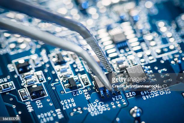 assembling a circuit board. - tweezers stockfoto's en -beelden