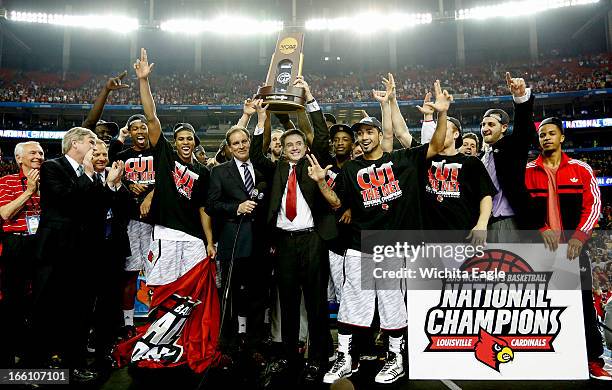 Louisville Cardinals head coach Rick Pitino celebrates with his team after defeating Michigan, 82-76, and winning the NCAA Men's Basketball...