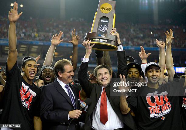 Louisville Cardinals head coach Rick Pitino celebrates with his team after defeating Michigan, 82-76, and winning the NCAA Men's Basketball...