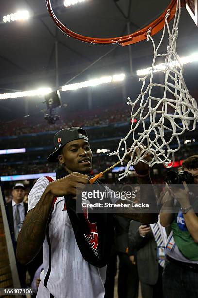 Injured guard Kevin Ware of the Louisville Cardinals celebrates as he cuts down the net after Louisville won 82-76 against the Michigan Wolverines...