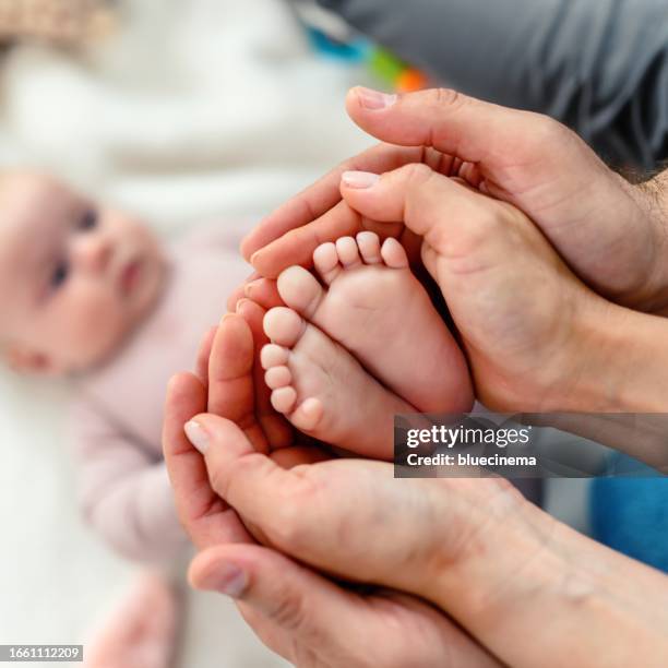 baby feet in parent's hands - labour childbirth stock pictures, royalty-free photos & images