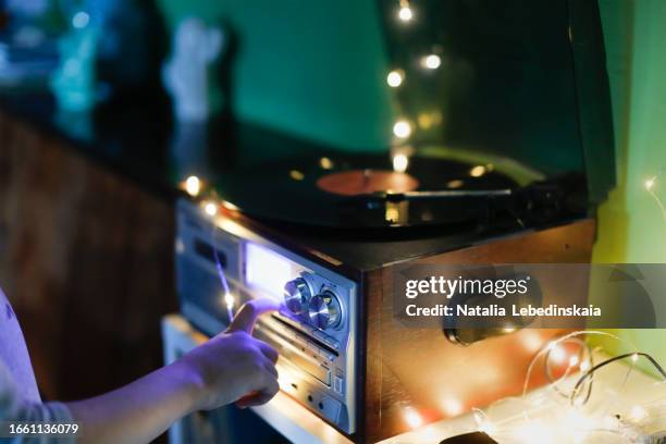 vintage sounds: child with record player, atmospheric photo. close-up hands at the night - precious collection home foto e immagini stock