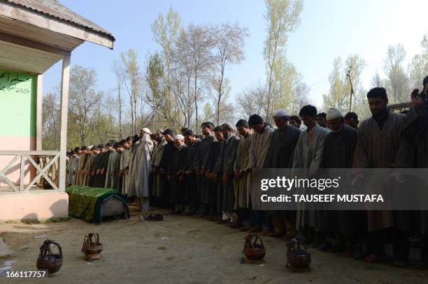 Kashmiri Muslim villagers offer prayers during the funeral of ruling National Conference sarpanch, Ghulam Mohammed Lone in Kulpora village of south...