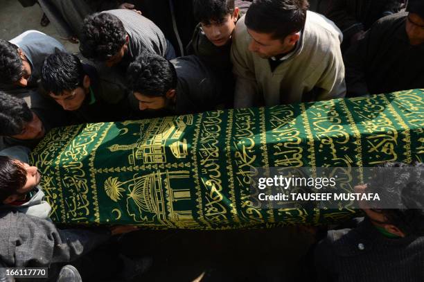 Kashmiri Muslim villagers carry the coffin of ruling National Conference sarpanch, Ghulam Mohammed Lone during the funeral in Kulpora village of...