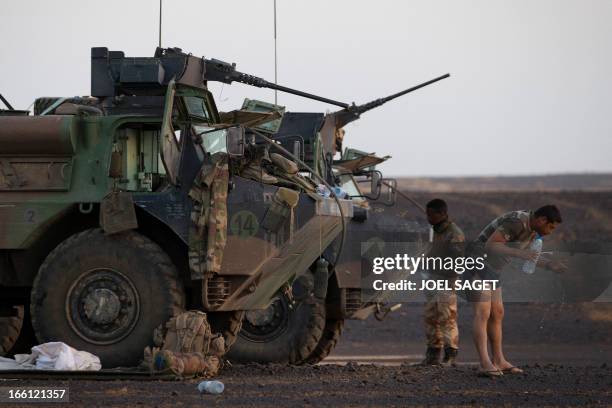 French soldiers from the 126th Regiment Infantery cleans his teeth near an armoured personnel carrier early in the morning on April 8, 2013 some 105...