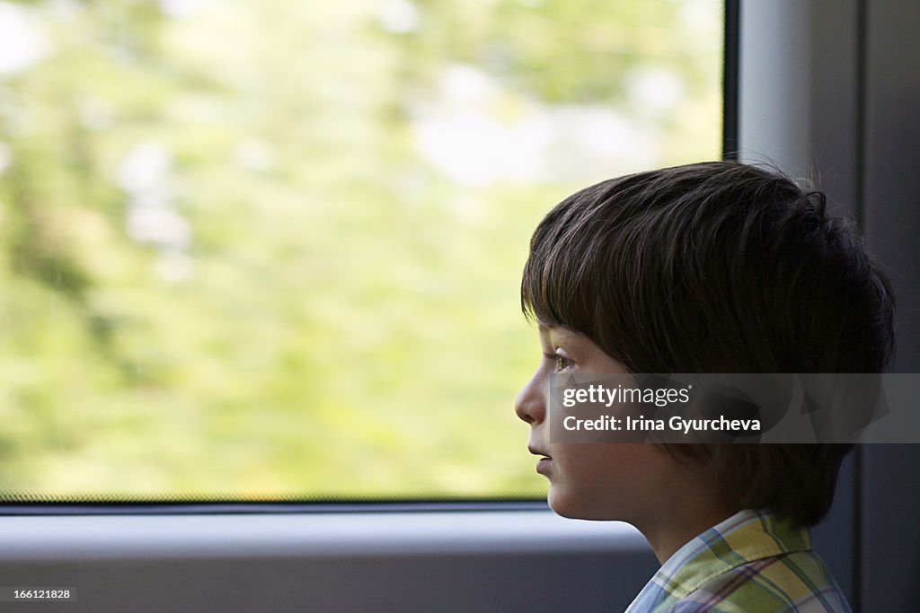 A boy looking out a train window