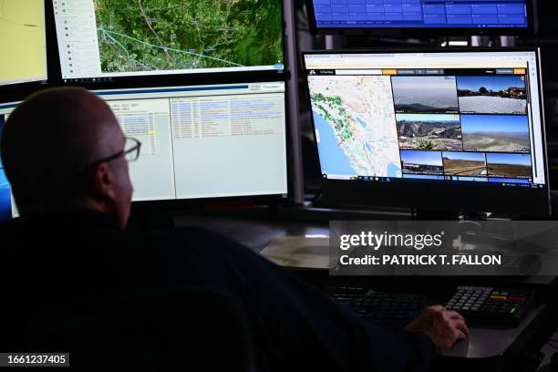 Cal Fire fire captain Kris Yeary views screens with dispatch logs and a view of some of the over 1,000 cameras with artificial intelligence...