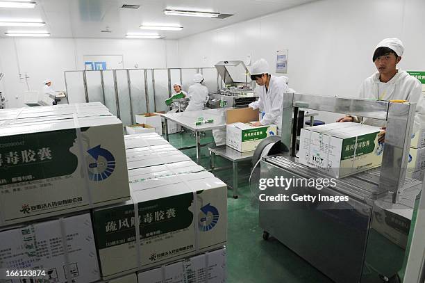 Employees work on the production line of Shufeng Jiedu Capsule, a Herbal Medicine for treating avian influenza patients, at a workshop of Anhui Jiren...