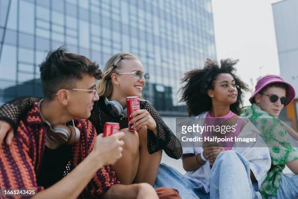 diverse group of generation z friends hanging out together, drinking soda from cans in the city. - dosen schießen stock-fotos und bilder