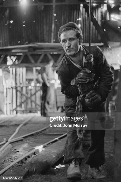 An Italian miner holding onto a rope with heavy duty gloves, Yorkshire, 1956. Original Publication: Picture Post - 8412 - Italian Miners In Yorkshire...