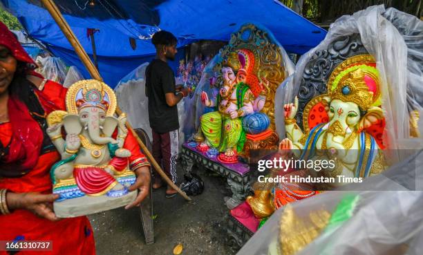 An artist gives finishing touches to idols of Ganesha on Mayaur Vihar near Akshardham Temple ahead of Ganesh Chaturthi on September 12, 2023 in New...