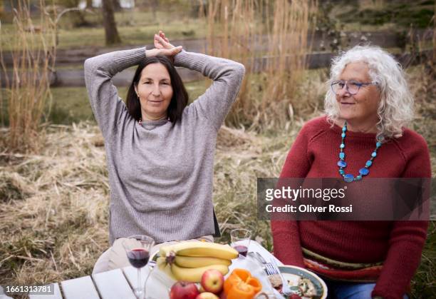 female friends sitting together at garden table - bell pepper field stock pictures, royalty-free photos & images
