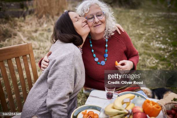 female friends hugging at garden table - bell pepper field stock pictures, royalty-free photos & images