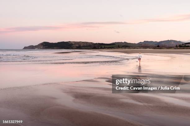 girl on new zealand beach with beautiful pink sunset - hawkes bay region fotografías e imágenes de stock