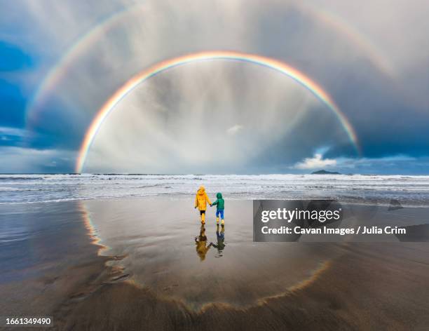 circle rainbow in new zealand with two children in center - arc en ciel photos photos et images de collection