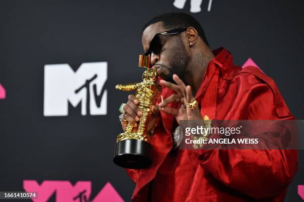 Producer-musician Sean "Diddy" Combs poses with the Global Icon award in the press room during the MTV Video Music Awards at the Prudential Center in...