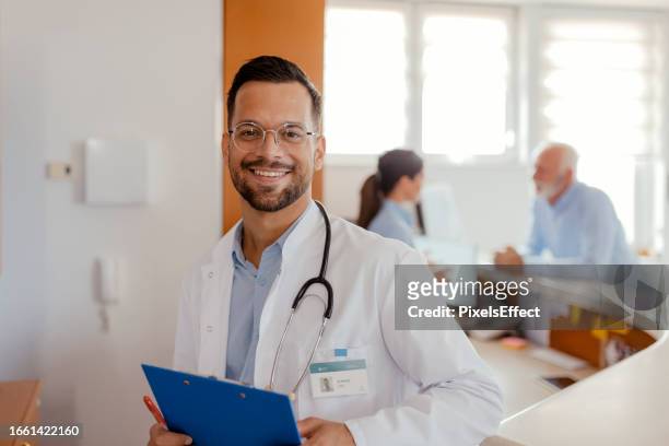 porträt eines arztes mit lächeln im krankenhaus - doctor smile stock-fotos und bilder
