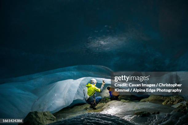 climate researchers measure temperature in cave below glacier - climate research stock pictures, royalty-free photos & images