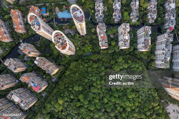 vertical plane aerial view of urban buildings in green forest - industrial district stockfoto's en -beelden