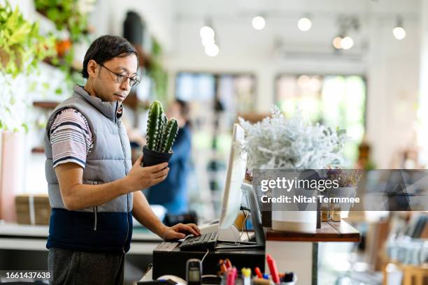 value-based pricing to increasing revenue, profitability, and customer motivation. a male japanese store owner input price of a product into a point of sale software via a computer at a cashier counter in his store. - labeling stock pictures, royalty-free photos & images