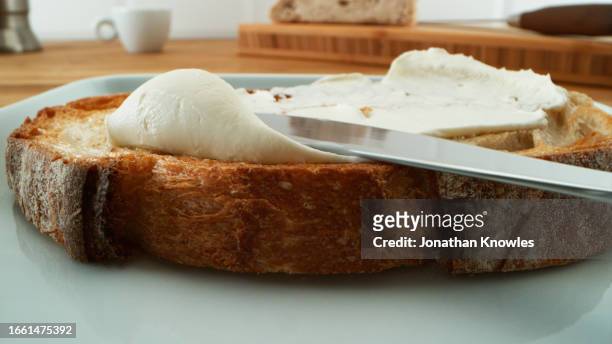 spreading cream cheese - küchenmesser stock-fotos und bilder