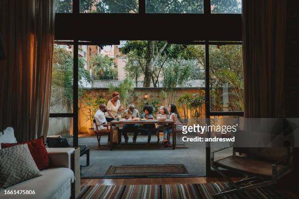 family gathered at the table at home - luxury family stockfoto's en -beelden